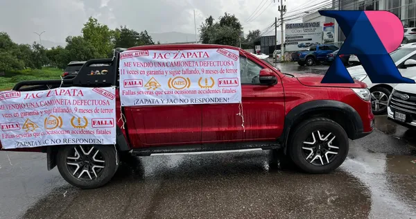 La camioneta permanece frente a la agencia JAC Zapata, con pancartas que detallan las fallas que ha presentado pese a ser nueva.