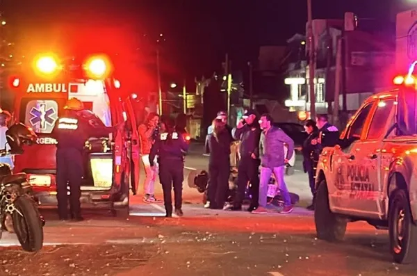 Accidente vial nocturno en bulevar Minero, Pachuca, con presencia de ambulancia, policías y motocicleta involucrada.