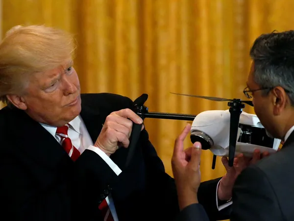 Donald Trump sostiene un dron mientras conversa con un especialista durante una presentación tecnológica