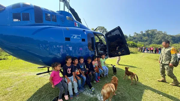 Niños de la Sierra Alta de Hidalgo corren para tomarse fotos en los helicópteros que tienen una semana abasteciendo de víveres a las comunidades que continúan incomunicadas por decenas de deslaves causadas por las intensas lluvias.