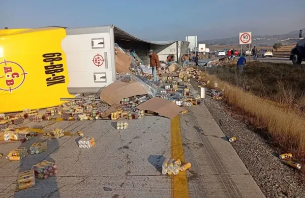 Tráiler volcado sobre la autopista Arco Norte con gente alrededor realizando rapiña de mercancía.