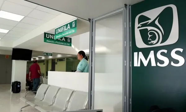 Hombre revisando su estado de cotización en una computadora con el sitio del IMSS abierto.