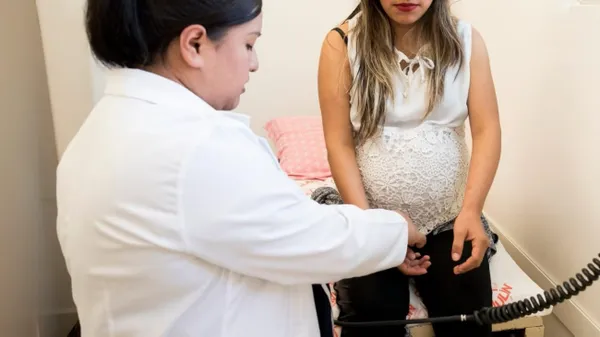 Mujer embarazada en consultorio con una médica